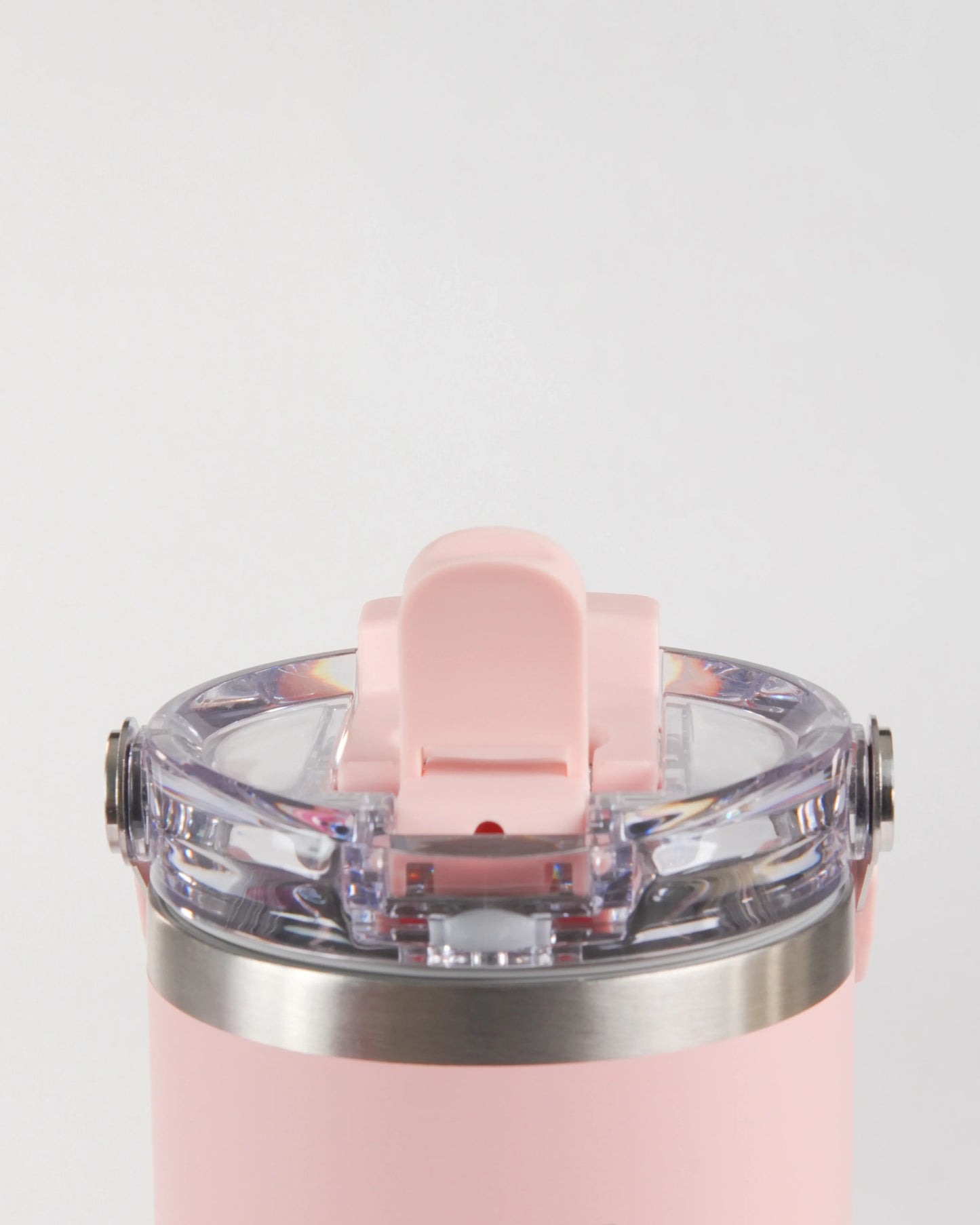 A close-up studio shot of the pink höhen Essential tumbler's lid, showcasing the transparent high-quality materials and stainless steel accents.