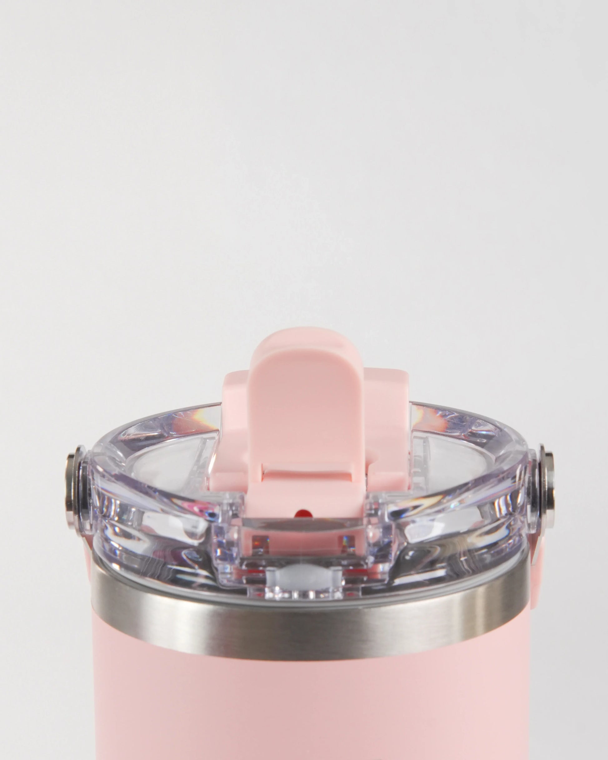 A close-up studio shot of the pink höhen Essential tumbler's lid, showcasing the transparent high-quality materials and stainless steel accents.
