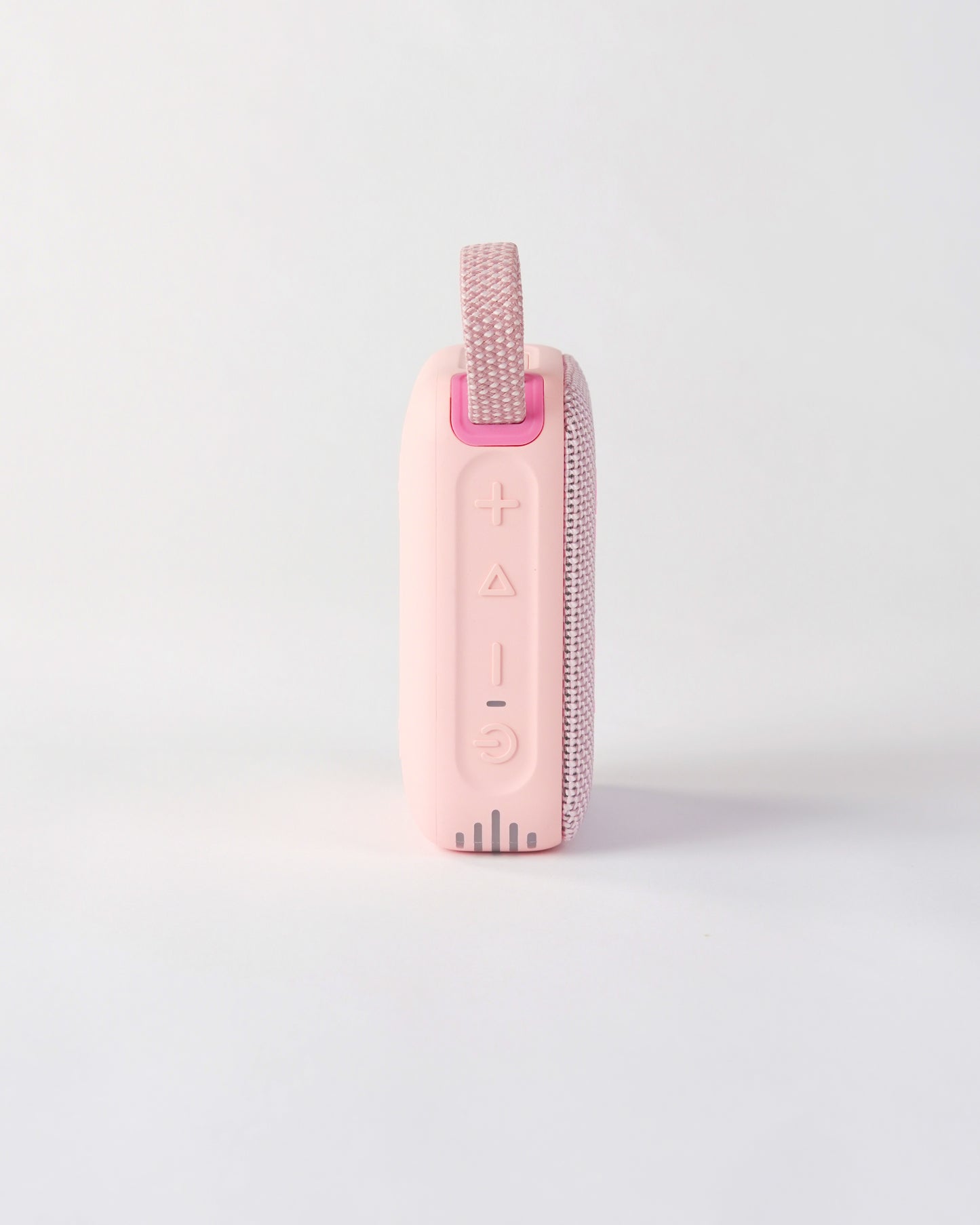 Side view of the pink höhen move wireless speaker highlighting the tactile control buttons for power, volume, and playback