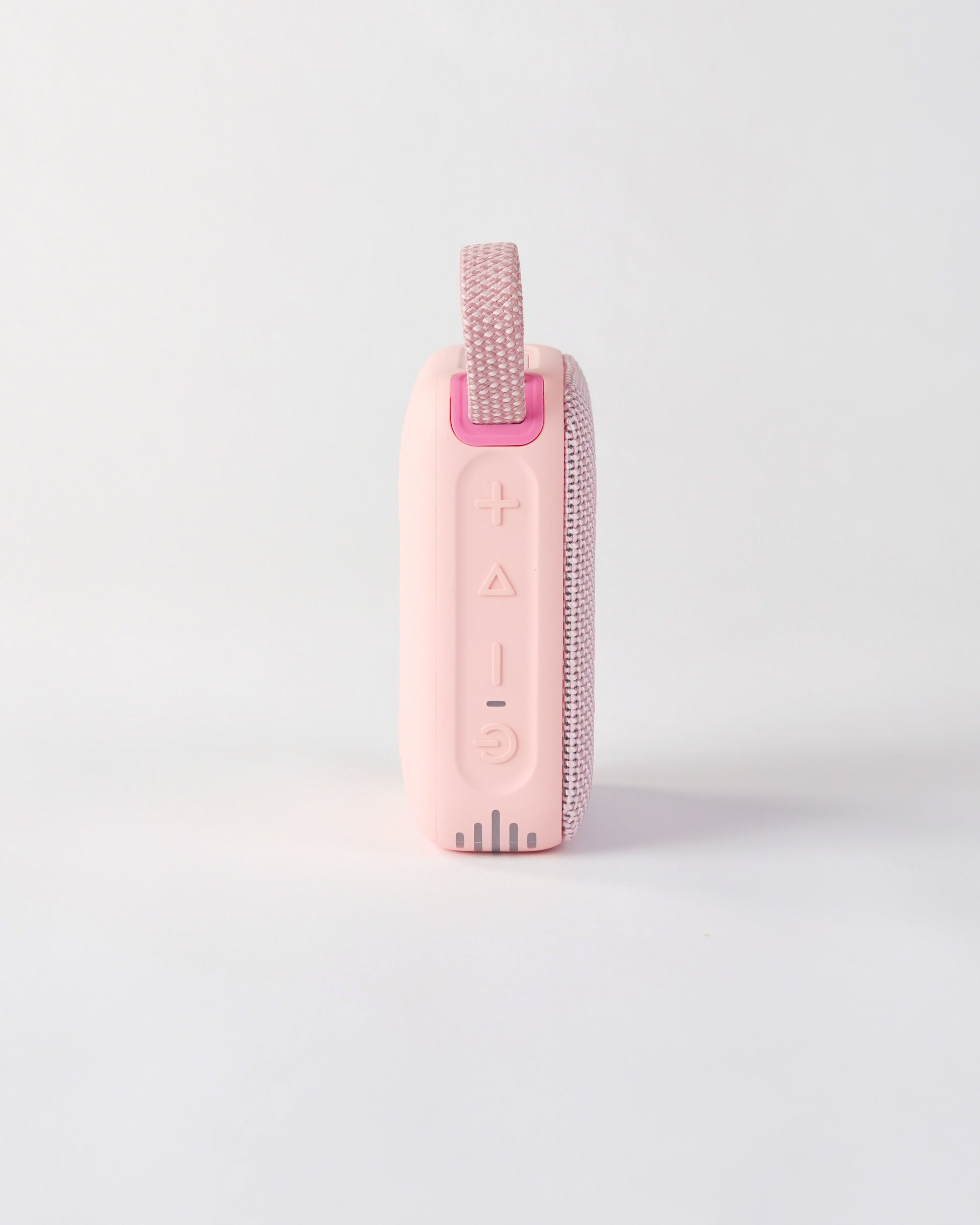 Side view of the pink höhen move wireless speaker highlighting the tactile control buttons for power, volume, and playback