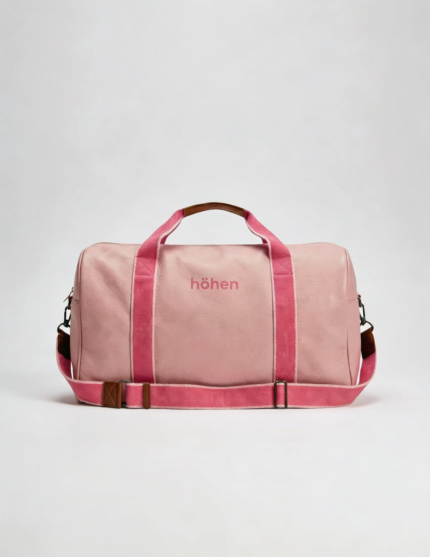 The höhen One pink bag with fuchsia straps and Höhen logo, front view on white background, women’s gym and travel bag.
